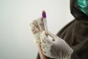 Pregnant woman holding her belly, with a healthcare provider explaining NIPT (Non-Invasive Prenatal Testing) options and benefits in a medical office setting.